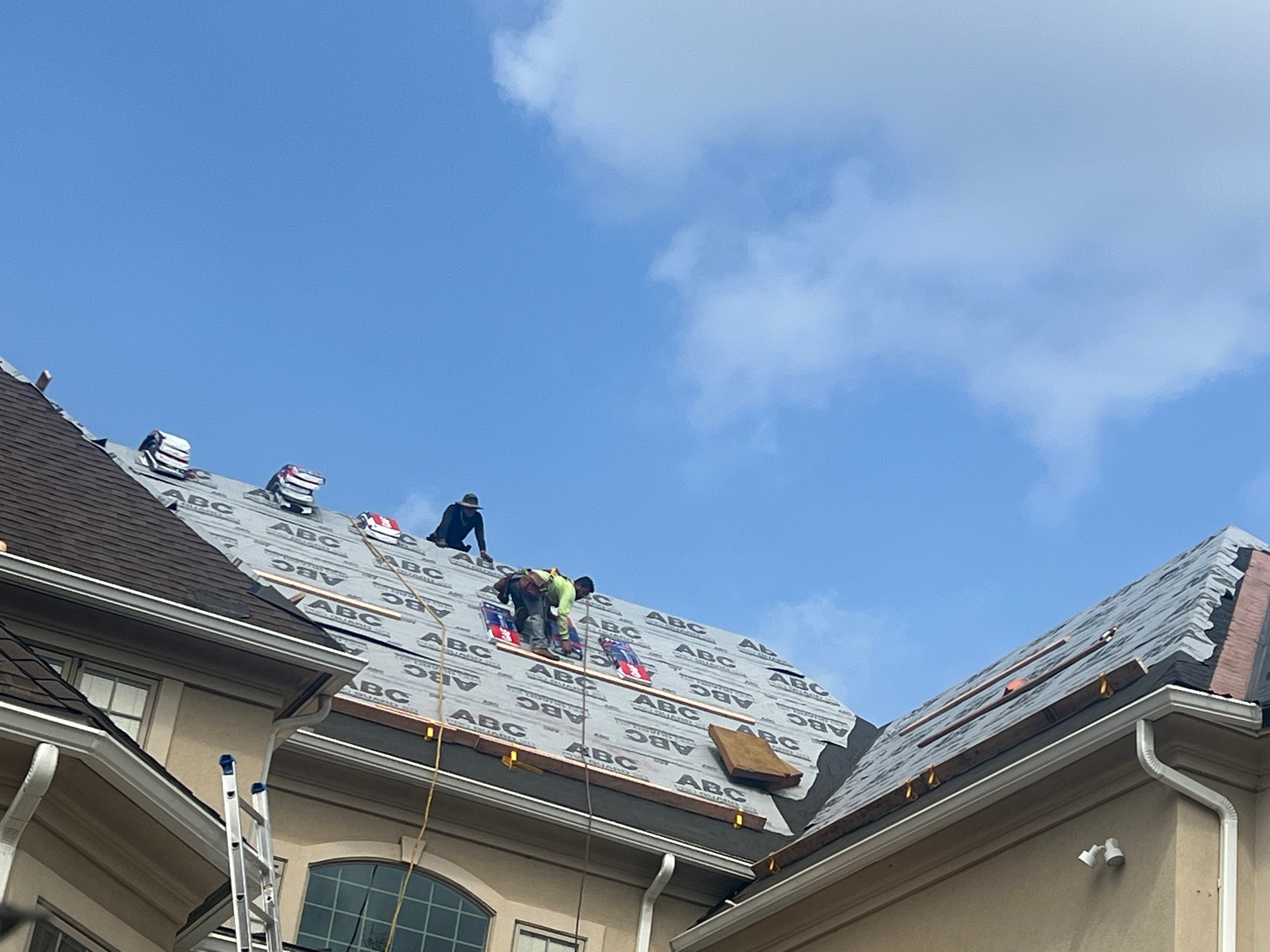 Workers on Roof Under Clear Sky